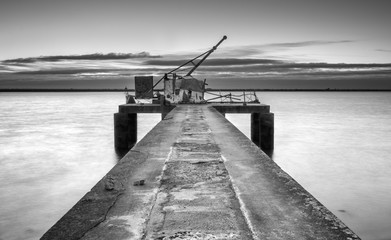 Ancient industrial pier, black and white pier with hoist - 121871281