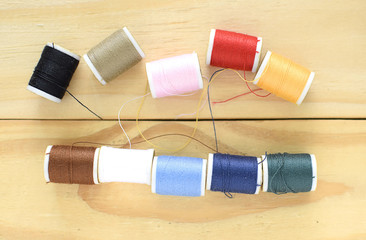 Fototapeta na wymiar colorful sewing threads on wooden background