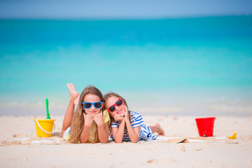 Adorable little girls during summer vacation. Kids with beach toys on the white beach