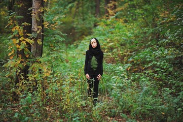 girl stands among the green forest and holding fern