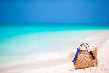 Fototapeta na wymiar Beach accessories - straw bag, headphones, toy plane and sunglasses on the beach