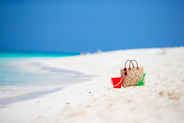 Beach accessories - straw bag, headphones, beach kids toys and sunglasses on the beach