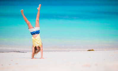 Adorable active little girl at beach during summer vacation