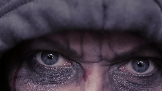 mad eyes of an evil man. Dirty face in blood. head in the hood