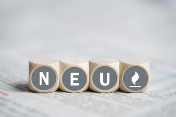 W&uuml;rfel mit Wort "Neu" auf einer Zeitung
