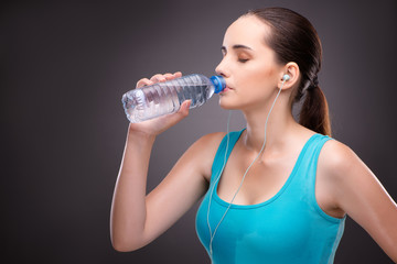 Woman doing sports with bottle of fresh water