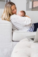 Mother carrying her baby in living room