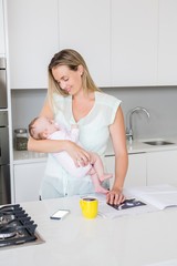 Mother carrying her baby in kitchen