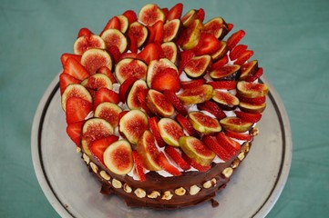 A vegan chocolate cake with fresh strawberries and figs