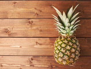 Raw whole pineapple on wooden surface table