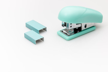Stapler and staples on white background
