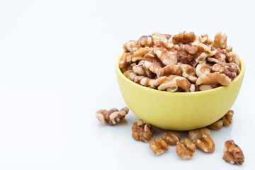 Walnuts in a bowl on a white background.