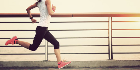 young fitness woman running at seaside