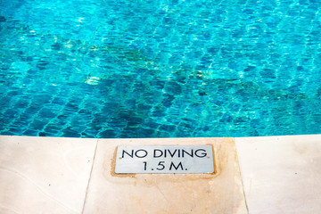 swimming pool edge with 'No Diving' warn sign