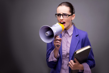 Young businesswoman yelling through loudspeaker