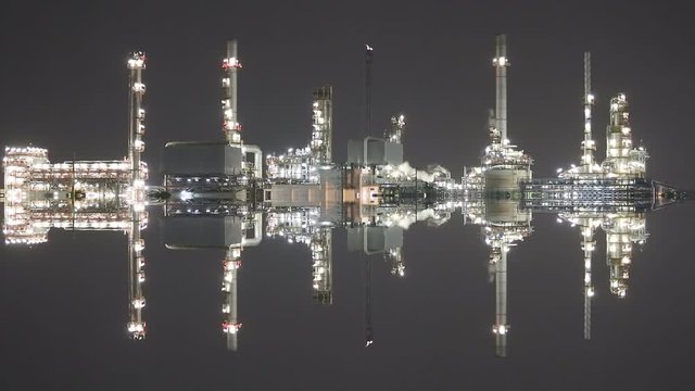 Twilight scene of oil refinery industrial plant with vertical mirror effect 