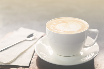 Beautiful heart shaped of Latte coffee art and spoon on table