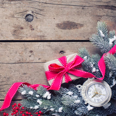 Wrapped christmas gift box, decorative clock and fur tree branch