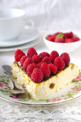 Cheesecake, souffle, cream mousse, pudding dessert with fresh raspberries and mint leaves on a white plate