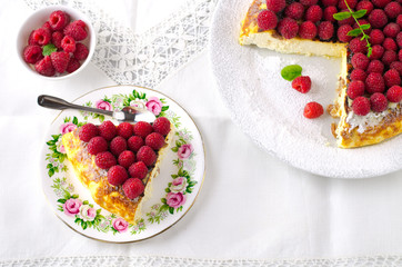 Cheesecake, souffle, cream mousse, pudding dessert with fresh raspberries and mint leaves on a white plate