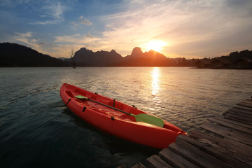 Silhouette scenery during sunset with kayak,canoe at natural attractions in Ratchaprapha Dam,Khao Sok National Park,SuratThani Province in Thailand. Traveling and recreation Concept.