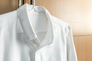 White shirt with long sleeves hanging on wardrobe