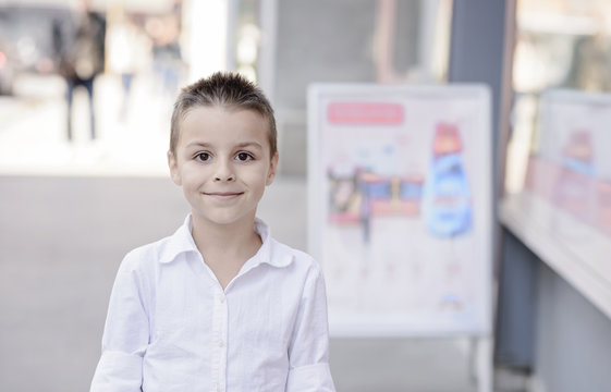 beautiful boy standing next to billboards 