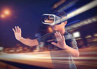 Double exposure. Afro-Amrican boy wearing virtual reality glasses and city nightlife background. Modern technology concept.