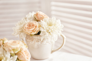 Bouquet of beautiful roses in a cup on a  table