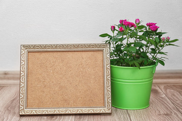 Roses in bucket and photo frame on floor