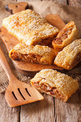 sliced pie stuffed with cabbage and sausages close-up. vertical
