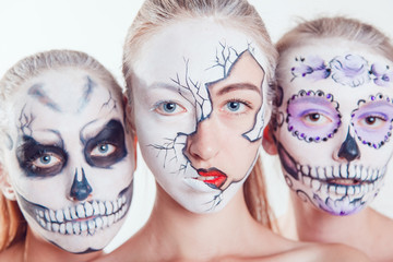 Three girls with Halloween face art on white background