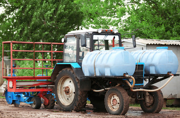 Obraz premium Tractor with tanks on the farmland