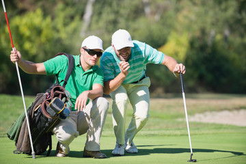 Golf. Golfer and caddy contemplating a putting shot