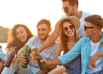 Group of friends hanging out with beer at the beach