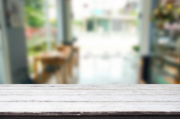 Selected focus empty brown wooden table and Coffee shop blur bac