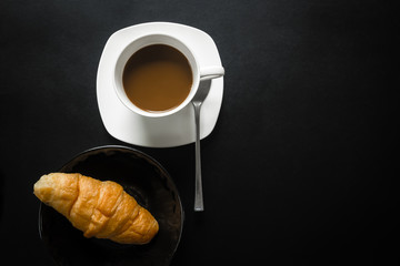 Coffee cup with croissant, Top view. Dark tone.