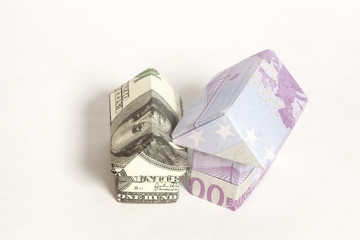 Origami house made of 500 euro and 100 dollar banknotes