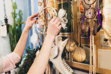Artisan hanging new dream catcher to other creations. Art installation of decorative elements and animal bones. Craftsman exhibition