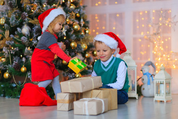 Fototapeta na wymiar Kids opening christmas presents in decorated living room