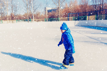 Fototapeta na wymiar cute little boy learning to skate in winter
