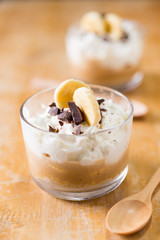 Banoffee pie in glass cup on table.
