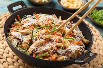 Rice noodles with chicken, mushrooms mun and vegetables in wook.