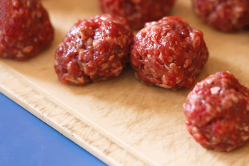 Raw meatballs on a wooden board
