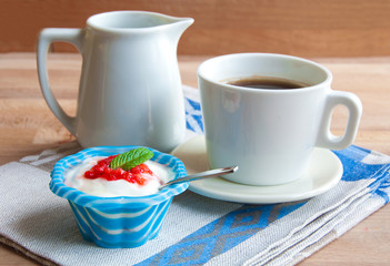 Yoghurt with strawberries and coffee for breakfast