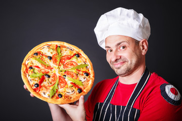 Portrait of happy attractive cook with a pizza in hands