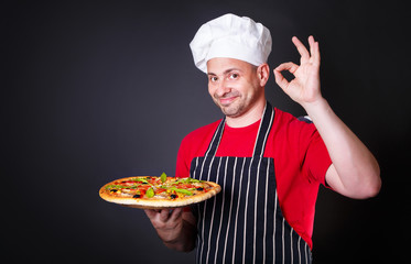 Portrait of happy attractive cook with a pizza in hands