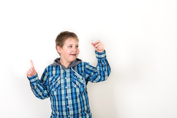 Smiling child holding tablet PC in hands. Idea concept. Photo shoot in the studio boy with tablet and a bulb-to-day knowledge