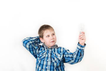 Smiling child holding tablet PC in hands. Idea concept. Photo shoot in the studio boy with tablet and a bulb-to-day knowledge
