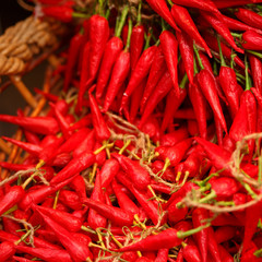 pile of small, red, very hot and spicy chilli peppers on an ital